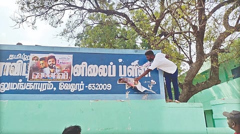 VCK cadre removing posters from the school?s name board in Vellore on Sunday.