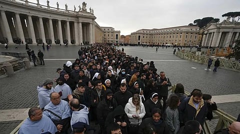 People wait in a line to enter Saint Peter's Basilica at the Vatican where late Pope Benedict 16 is being laid in state at The Vatican.