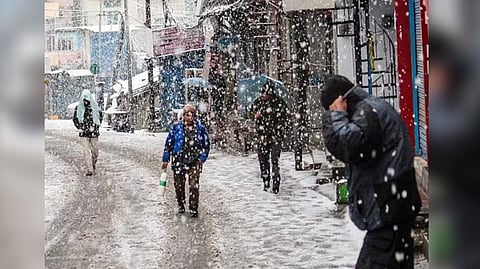 Commuters walking through heavy snowfall in Joshimath