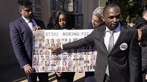 Paul Njoroge (right) points to photos of his wife and three children that were killed in the 2019 crash of Ethiopian Airlines 737 Max aircraft after a federal court hearing in Fort Worth, Texas.