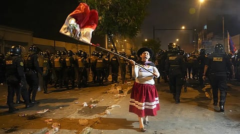 A woman waves a Peruvian flag during an anti-government protest