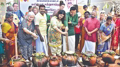 Collector Rahul Nath making Pongal along with foreign tourists at Dakshinachitra in Muttukadu