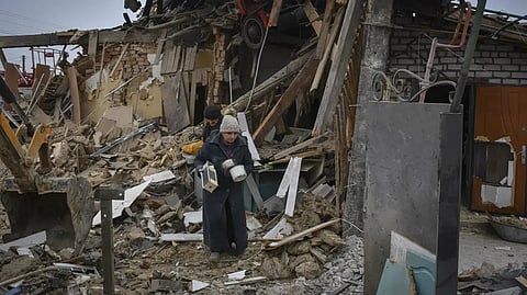 Local residents carry their belongings as they leave their home ruined in the Saturday Russian rocket attack in Zaporizhzhya, Ukraine.