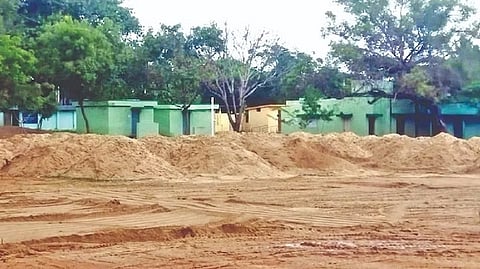 Sand dumped in the campus of the government higher secondary school at Vallimalai in Katpadi taluk