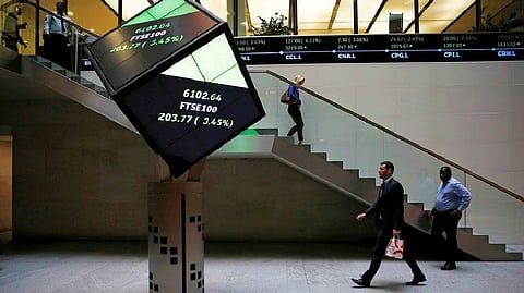 People walk through the lobby of the London Stock Exchange