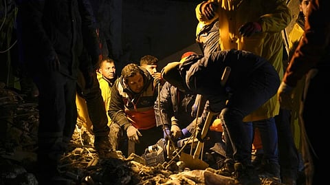 Emergency teams search in the rubble for people in a destroyed building in Adana, Turkey, Monday.