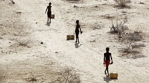 Young boys pull containers of water amid a drought