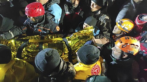 Rescue workers and medics carry a young woman they have rescued from the debris of a collapsed building in Sanliurfa, southern Turkey