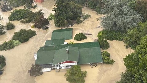 An NH90 helicopter and crew recover people from the rooftops of their homes in Esk Valley