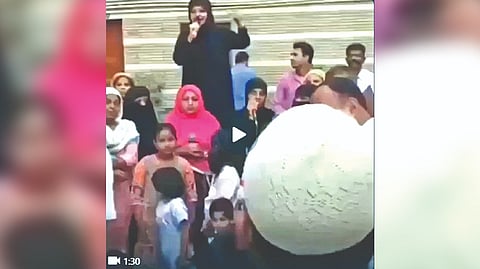 The people, led by a woman in a burqa, shout slogans targeting the Opposition leaders.