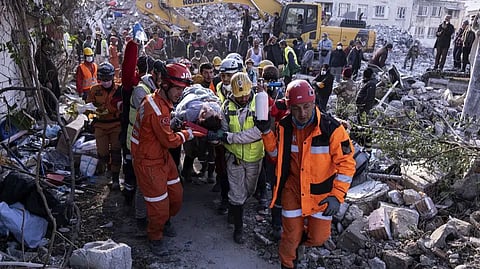 Rescue workers and medics pull out a person from a collapsed building in Antakya, Turkey, Wednesday.