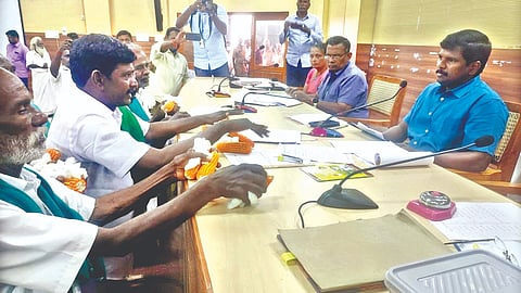 Farmers showing maize to officials demanding increase in prices in Tiruchy on Friday