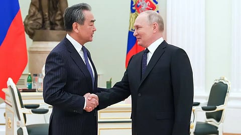 Russian President Vladimir Putin greets Chinese Communist Party's foreign policy chief Wang Yi during their meeting