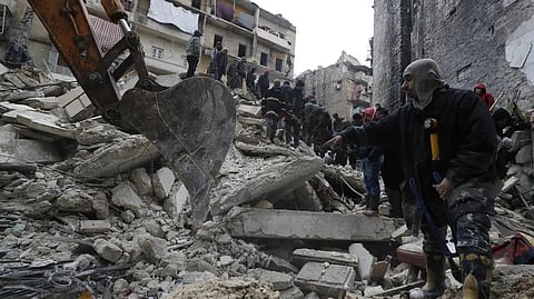 Syrian Civil Defense workers and security forces search through the wreckage of collapsed buildings, in Aleppo, Syria.