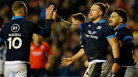 Scotland's Stuart Hogg celebrates scoring their seventh try with Finn Russell and Sione Tuipulotu Actio