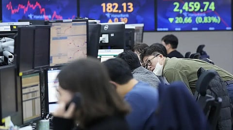Currency traders work at the foreign exchange dealing room of the KEB Hana Bank headquarters in Seoul, South Korea, Monday.