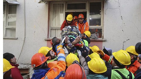 Rescue teams pull out a person from the debris of collapsed buildings in Hatay, southern Turkey.