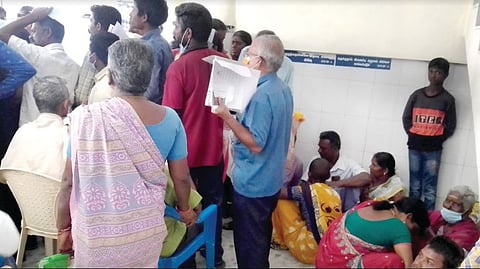 Differently abled person and attendants standing in line at Vellore Government Medical College