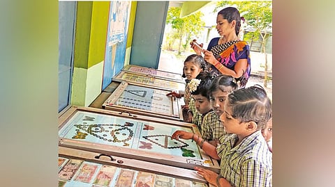 Students looking at Kathiresan?s coins collection at Kurinji Government Middle School in Pattukkottai on Thursday.