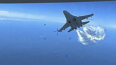A Russian Su-27 approaching the back of the MQ-9 drone and beginning to release fuel as it passes