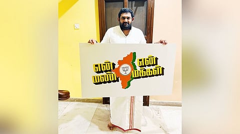 Amar Prasad Reddy holding the "En Mann En Makkal" placard