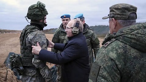 Russian President Vladimir Putin speaks to a soldier as he visits a military training center