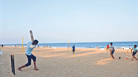 A group of boys playing cricket on Tiruvanmiyur beach