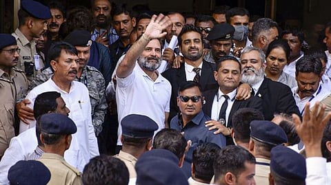 Congress leader Rahul Gandhi waves at supporters as he leaves the Surat district court after filing an appeal challenging his conviction and sentencing in the 2019 criminal defamation case over the "Modi surname" remark, Surat, April 3, 2023.