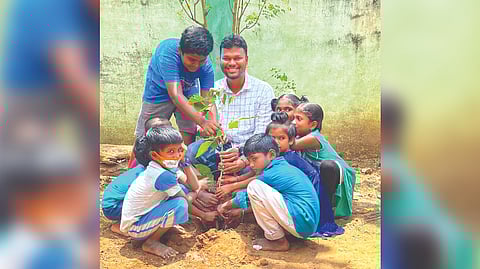 Nimal Raghavan planting a sapling with children