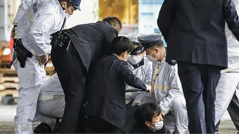 A man believed to be a suspect, center on the ground, is caught by police after he allegedly threw ?the suspicious object,? as Japanese Prime Minister Fumio Kishida visited Saikazaki port for an election campaign event in Wakayama