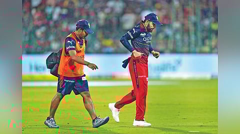 Virat Kohli limps off the field.