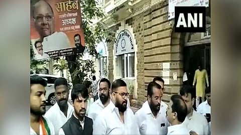 NCP party workers raise slogans in support of Sharad Pawar.