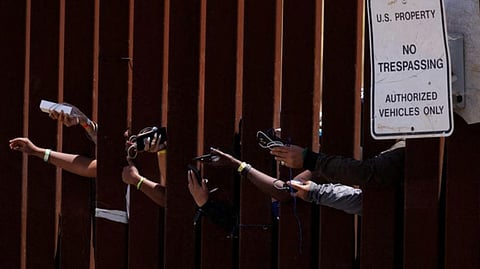Migrants gather along the U.S. Mexico border near San Diego before the lifting of Tile 42