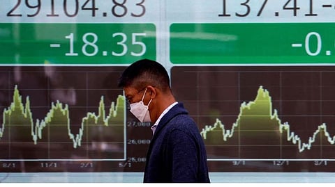 A man walks past an electric monitor displaying Nikkei share average and the Japanese yen exchange rate against the US dollar outside a brokerage in Tokyo, Japan May 2, 2023.