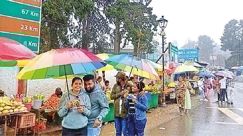 Tourists with umbrellas as rain poured in Ooty