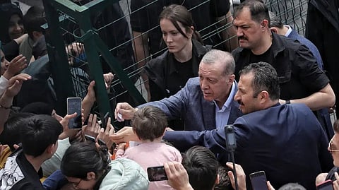 Turkey's President Recep Tayyip Erdogan with supporters at a polling station, in Istanbul, Turkey, Sunday, May 14, 2023.