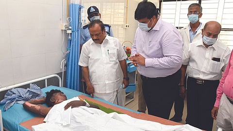Labour Minister CV Ganesan visiting an injured migrant worker at Karur Government Medical College Hospital on Monday