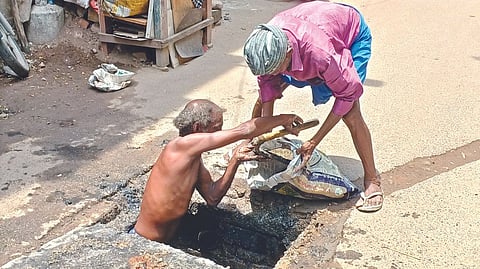 Workers cleaning a sewer line without any safety gear