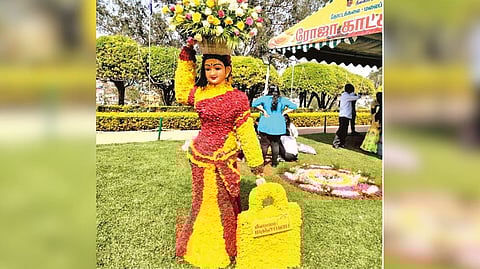 Floral structure of a woman carrying a yellow bag (manjappai) in Ooty