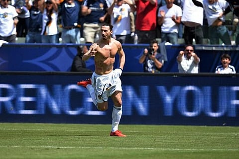 LA Galaxy forward Ibrahimovic pulls off his jersey as he celebrates scoring his first goal