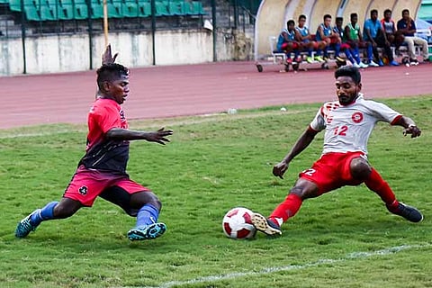 Forward Elavarasan of Indian Bank (l) battles for possession with a SR player during their match