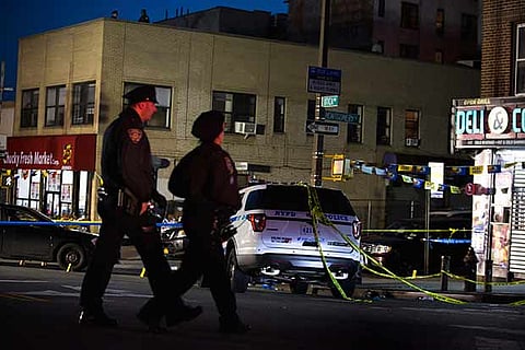 Officers walk past the scene where police shot and killed a man in the Crown Heights , New York.(AFP