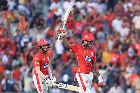 Kings XI Punjab batsman KL Rahul raises his bat after he completes his half century