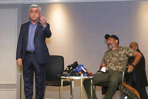 Armenian PM Serzh Sarkisian, left, gestures as he leaves a meeting with protest leader Nikol Pashinyan
