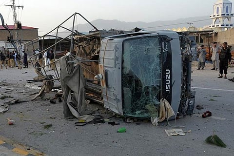 Policemen and locals gather near the site of three suicide bomb attacks