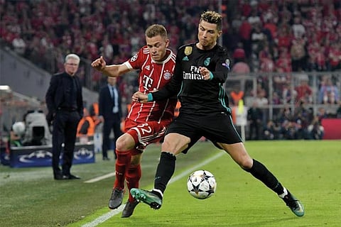 Bayern Munich's Joshua Kimmich in action with Real Madrid's Cristiano Ronaldo