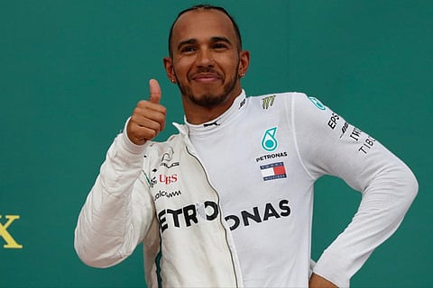 Lewis Hamilton celebrates on the podium after winning the race
