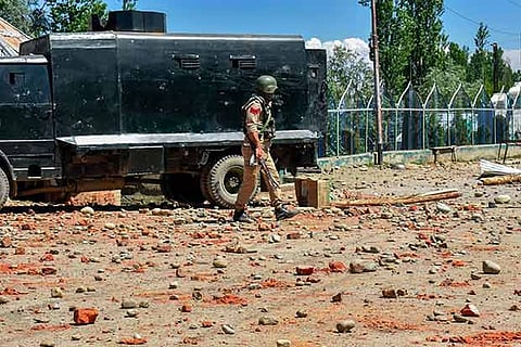 A policeman walks past the site where an encounter between security forces and militants took place