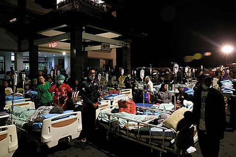 Patients are seen outside a hospital following a strong earthquake on Lombok island, Indonesia