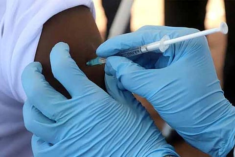 A WHO worker administers a vaccination during a campaign aimed at beating an outbreak of Ebola